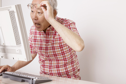 パソコンを見て驚いている老人